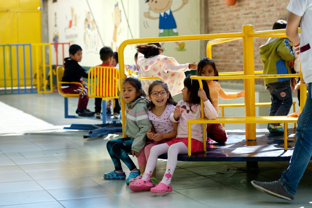 Kinder vergnügen sich auf dem Spielplatz im Innenhof, Montessori-Kindergarten und -Grundschule "Kinderhaus Santa Maria Magdalena Postel", Cochabamba, Departamento Cochabamba, Bolivien; Foto: Florian Kopp/SMMP