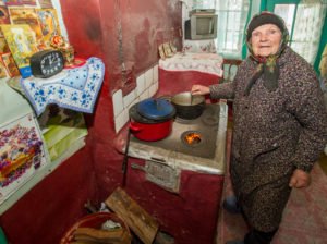 Die 89-jährige Maria kocht sich ein Süppchen. Ihr Sohn lebt in Italien, ihr Mann ist schon lange tot. Auch in diesem Winter wird das Brennholz wieder knapp. Juliana Ciceu bringt ihr ab und zu einen neuen Beutel vorbei. Foto: SMMP/Ulrich Bock